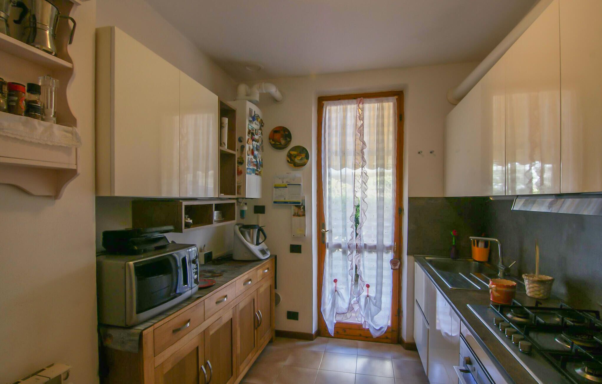 Una cocina compacta con microondas, estufa y armarios.
