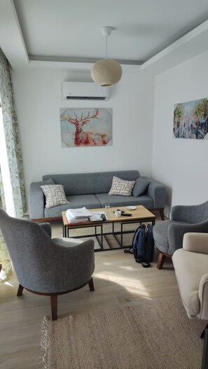 A modern living room with a grey sofa, a coffee table, and two armchairs. - Tivat Terrace Suites (Tivat)