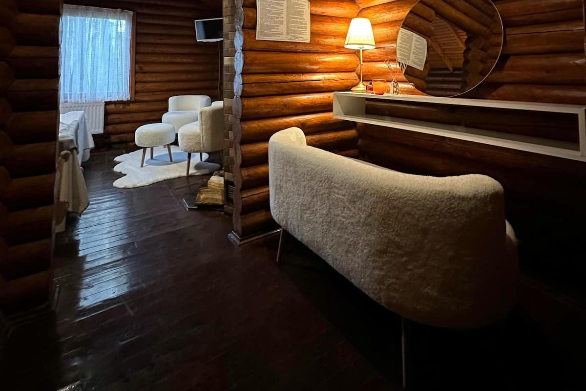 Interior de una cabaña de madera con una chimenea acogedora, un televisor de pantalla plana y un espacio de estar confortable.