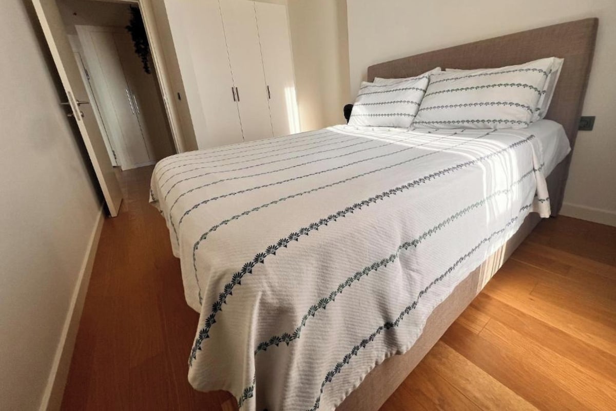 Un dormitorio con una cama, un armario y una puerta que da a otra habitación.