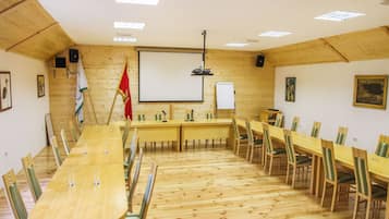 A conference room with a long table, chairs, a whiteboard, and a projector.