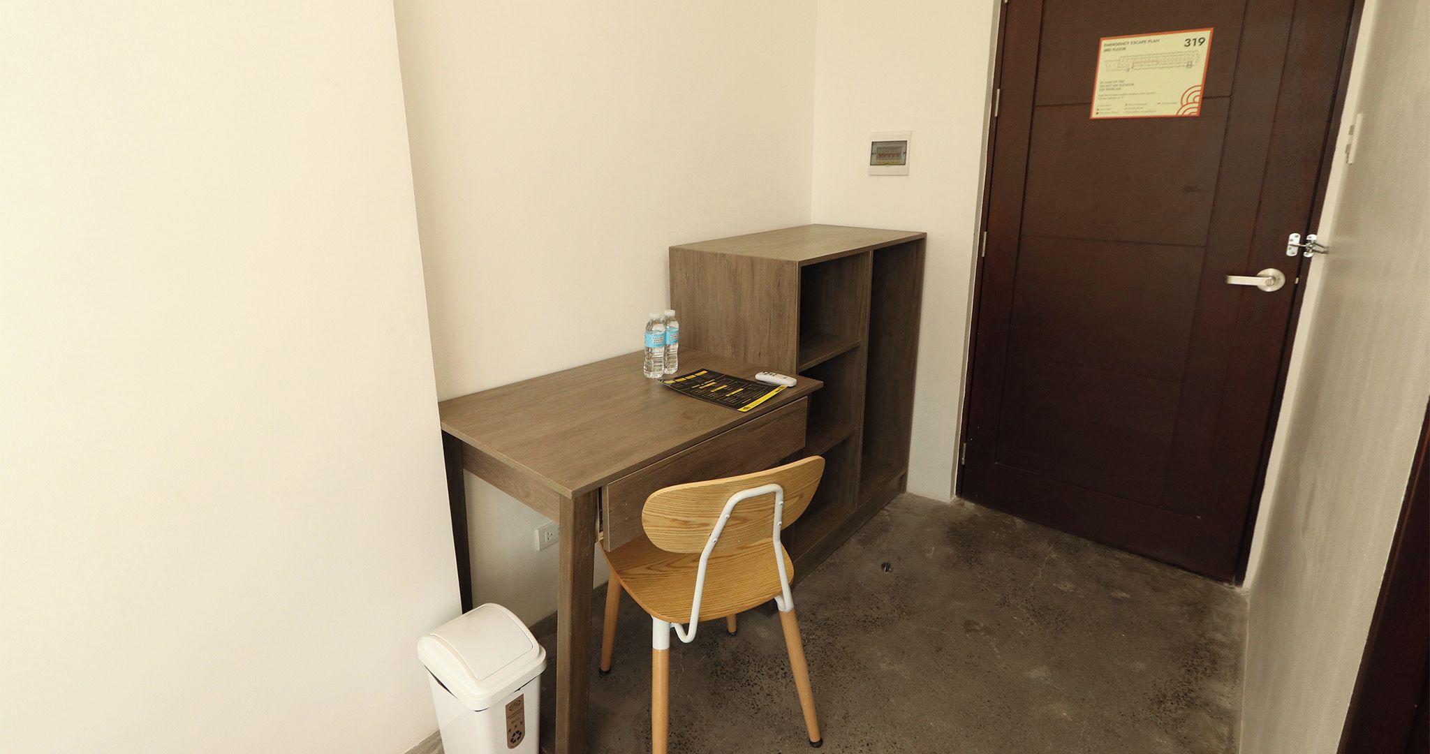 Una oficina pequeña y privada con un escritorio, una silla y una puerta con el símbolo del número.