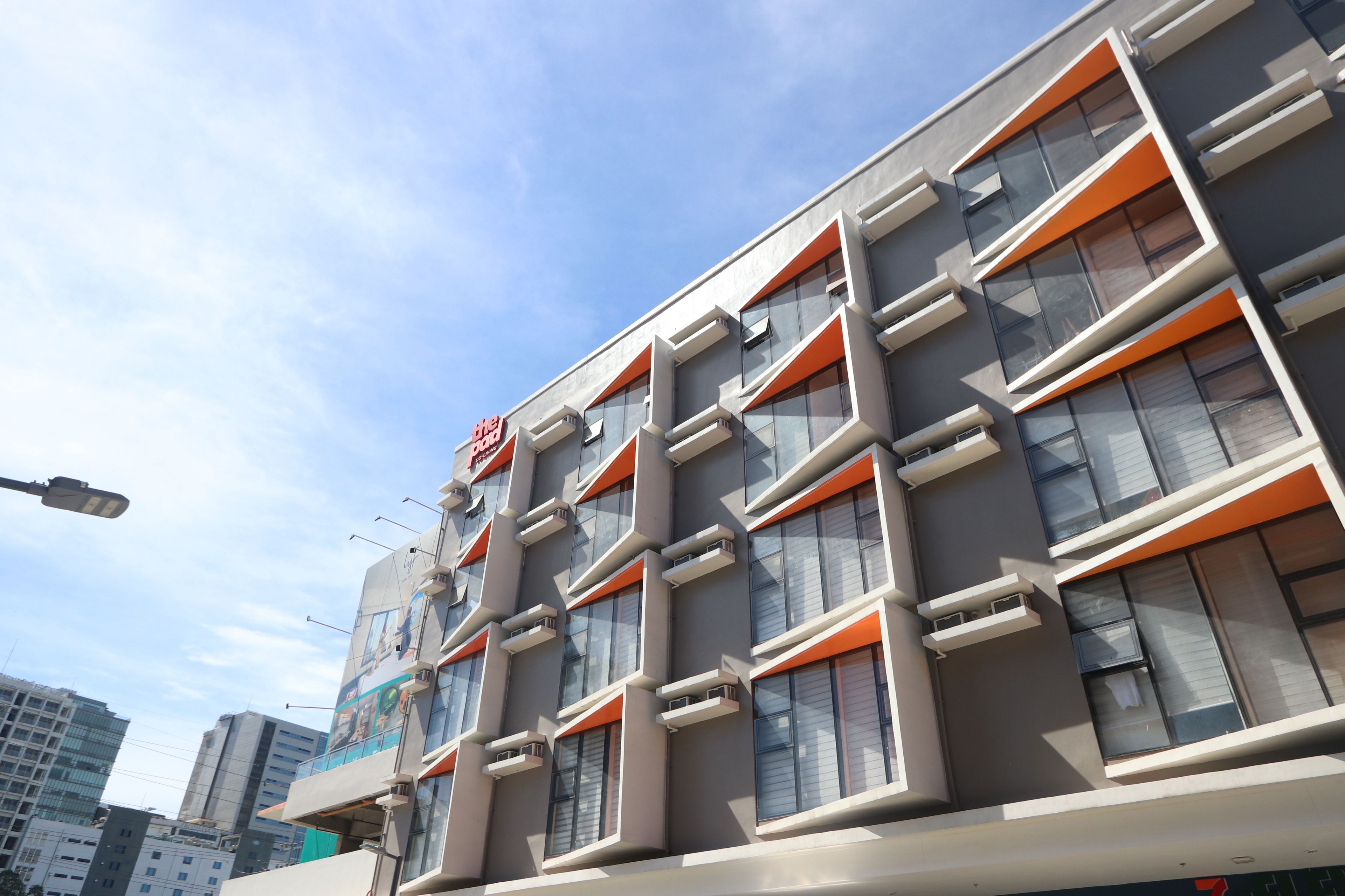 A modern building with multiple floors, large windows, and a prominent sign.
