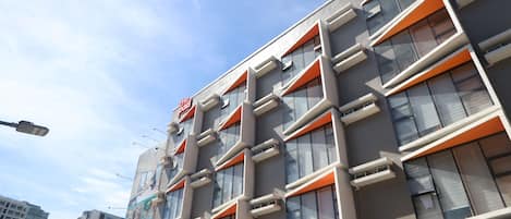 A modern building with multiple floors, large windows, and a prominent sign.