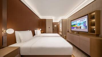 A hotel room with a large bed, a TV on the wall, and a wooden panel design.
