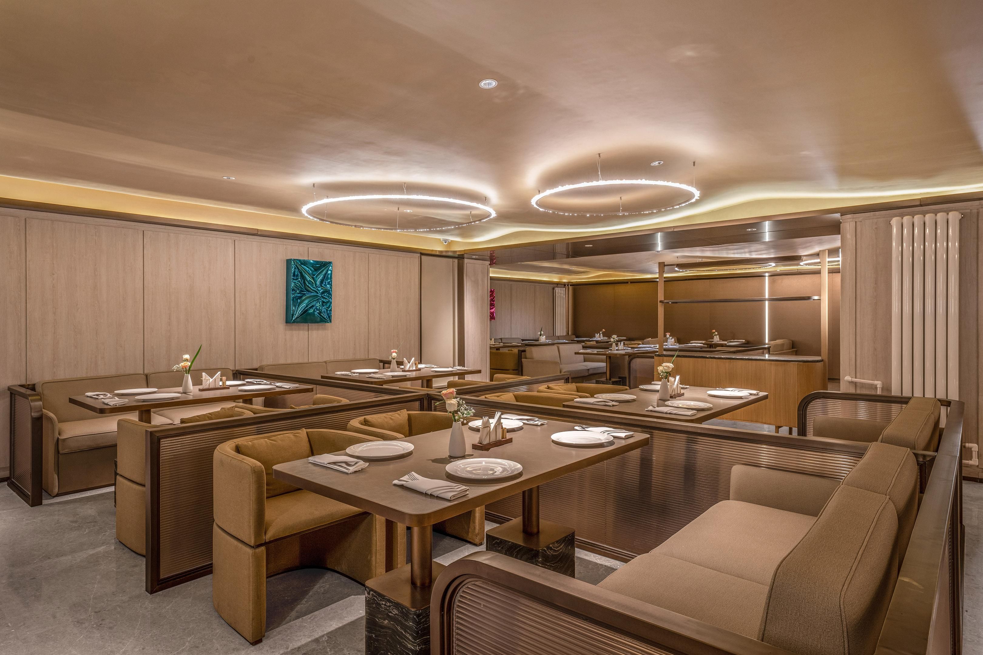 A modern dining area with booth seating and a central island, equipped with tables and chairs.