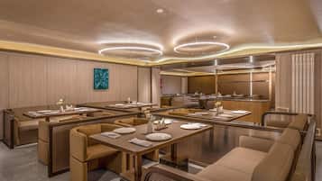 A modern dining area with booth seating and a central island, equipped with tables and chairs.