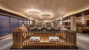 Disposição moderna de buffet, com ilha central, diversas estações de serviço e design de interiores contemporâneo.