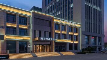 Un hôtel doté d’une façade moderne, de plusieurs étages et d’une enseigne lumineuse.