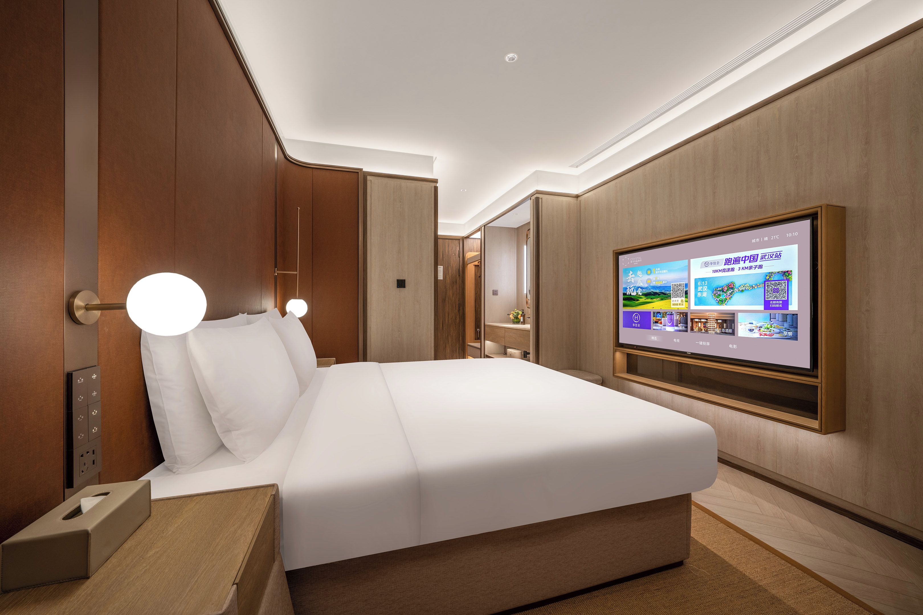 A hotel room with a bed, bedside table, wall-mounted TV, and wooden paneling.