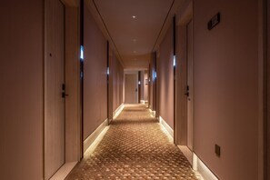 A hotel hallway with carpeted floors, doors on both sides, and recessed lighting. - Crystal Orange Hotel Beijing Yizhuang JD (Beijing)
