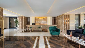 Un vestíbulo moderno con mostrador de recepción, zona de estar y una pared decorativa.