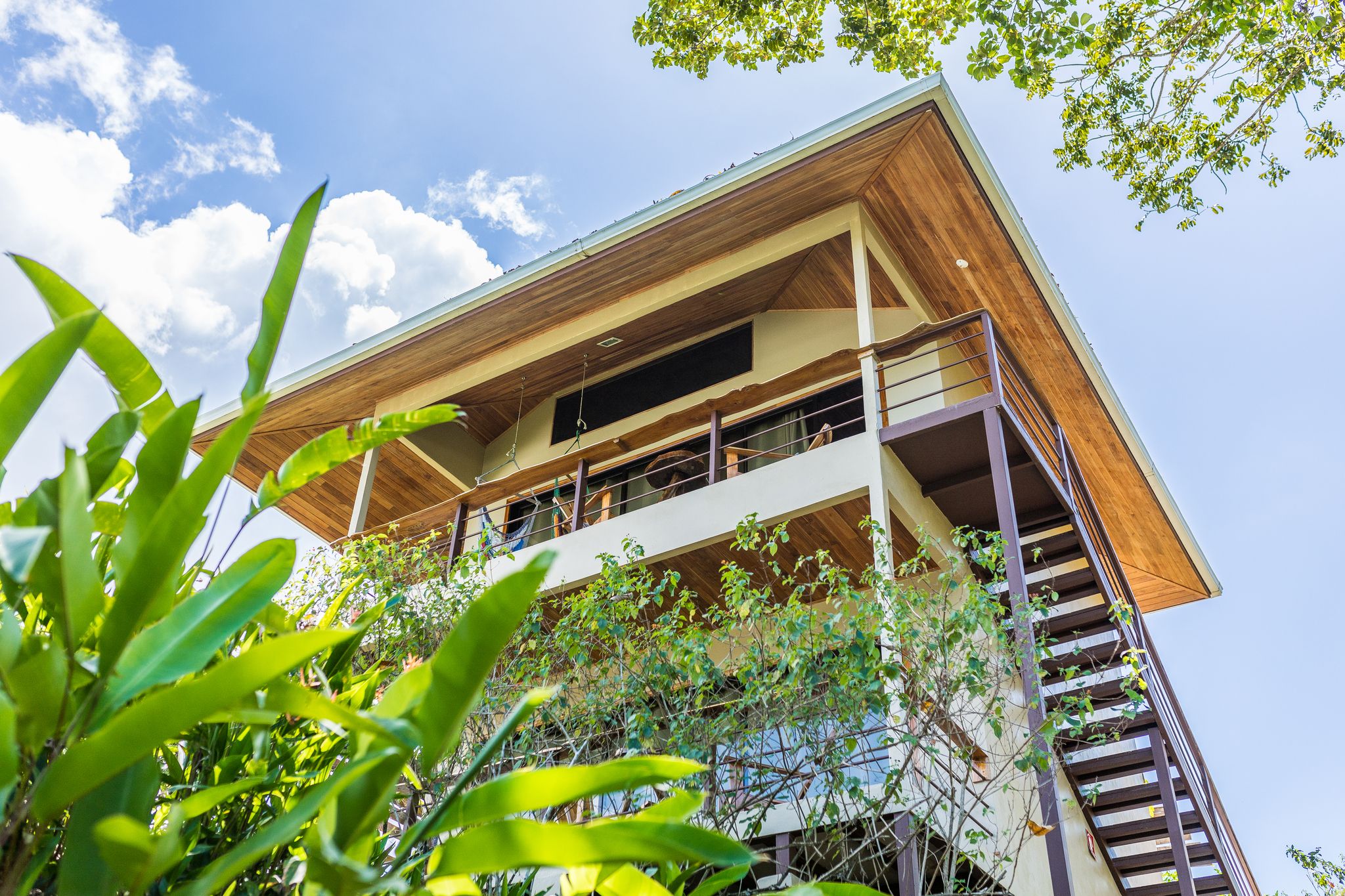 A multi-story building with a wooden facade, balconies, and a view of the sky.