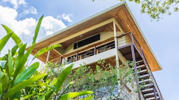 A multi-story building with a wooden facade, balconies, and a view of the sky.