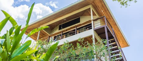 A multi-story building with a wooden facade, balconies, and a view of the sky.