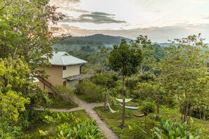A house with a garden path leading to a hammock, surrounded by lush greenery and hills in the background. - Drake Bay Getaway Resort By Sandglass (Drake Bay)
