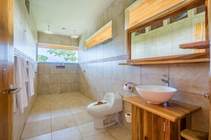Une salle de bain comprenant des toilettes, un lavabo et un espace douche.
