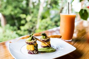 A plate of food with a drink on a table. - Drake Bay Getaway Resort By Sandglass (Drake Bay)