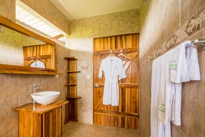 A bathroom with a wooden vanity, a large sink, a mirror, and a towel rack. - Drake Bay Getaway Resort By Sandglass (Drake Bay)