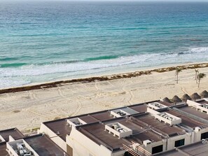 A beachside hotel with multiple rooftop terraces, a sandy beach, and a view of the ocean. - Casa Laurel (Cancun)