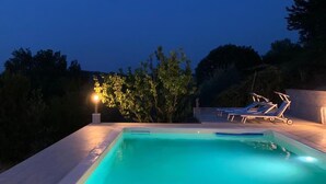 A swimming pool with a light source, two lounge chairs, and a tree in the background. - Lovely home in Casciana Terme (Casciana Terme)