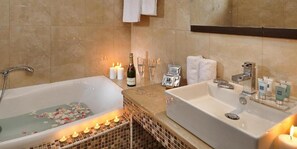 A bathroom with a bathtub, a sink, candles, and toiletries. - Noverian Scenic Crete 5 Hilltop Villa Resort &spa (Hersonissos)