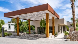 A modern building with a covered patio area, large windows, and a stone wall. - Sagredo Boutique Hotel And Spa (Kos)
