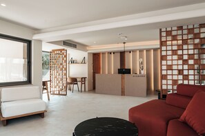Ein moderner Empfangsbereich mit einem Holztisch, einer Couch und einer Sitzecke.