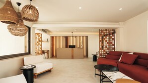 A modern living area with a sofa, a table, and a reception desk. - Sagredo Boutique Hotel And Spa (Kos)