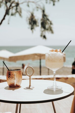 Ein Tisch mit einem Getränk und einem dekorativen Gegenstand am Strand.