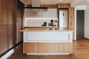 Une cuisine moderne avec un îlot central en bois, des appareils électroménagers intégrés et une porte coulissante.