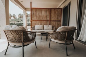 A balcony with wicker chairs, a sofa, and a glass table. - Sagredo Boutique Hotel And Spa (Kos)