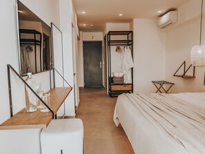 Ein Schlafzimmer mit einem Bett, einem Nachttisch, einem Spiegel und einem Kleiderschrank.