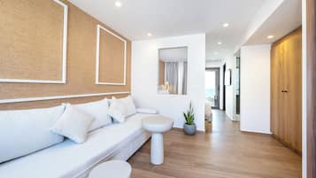 Un salon moderne avec un canapé blanc, une table basse ronde et une plante en pot.