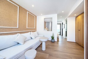 A modern living room with a white sofa, a round coffee table, and a potted plant. - Sagredo Boutique Hotel And Spa (Kos)