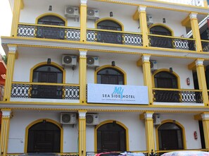 A multi-story hotel with balconies, air conditioning units, and a sign indicating it is the 'SEA SIDE HOTEL.' - My Sea Side Budget Stay (Calangute)