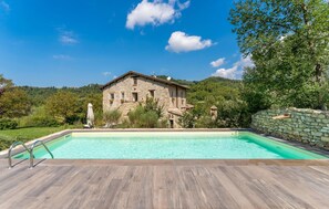 A stone house with a swimming pool, surrounded by greenery and hills. - Awesome home in Collazzone (Collazzone)