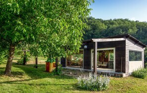 A wooden cabin with large windows, surrounded by lush greenery and trees. - Awesome home in Collazzone (Collazzone)