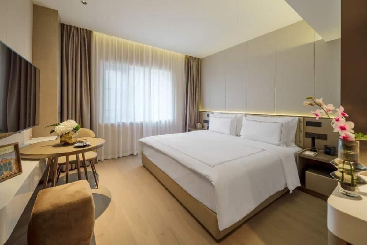Una habitación de hotel moderna con una cama grande, un escritorio y una silla.
