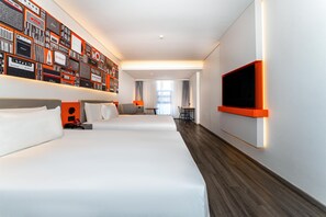 Habitació d'hotel amb dos llits, una televisió, una paret amb dissenys de ràdios antigues i vista al passadís.