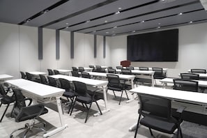 A conference room with multiple tables and chairs, a large screen, and a projector. - Ibis Xian Bell Tower Huimin Street (Xi'an)