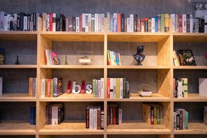 Una prestatgeria amb llibres i objectes decoratius, incloent-hi un bust i una maqueta de la Torre Eiffel.