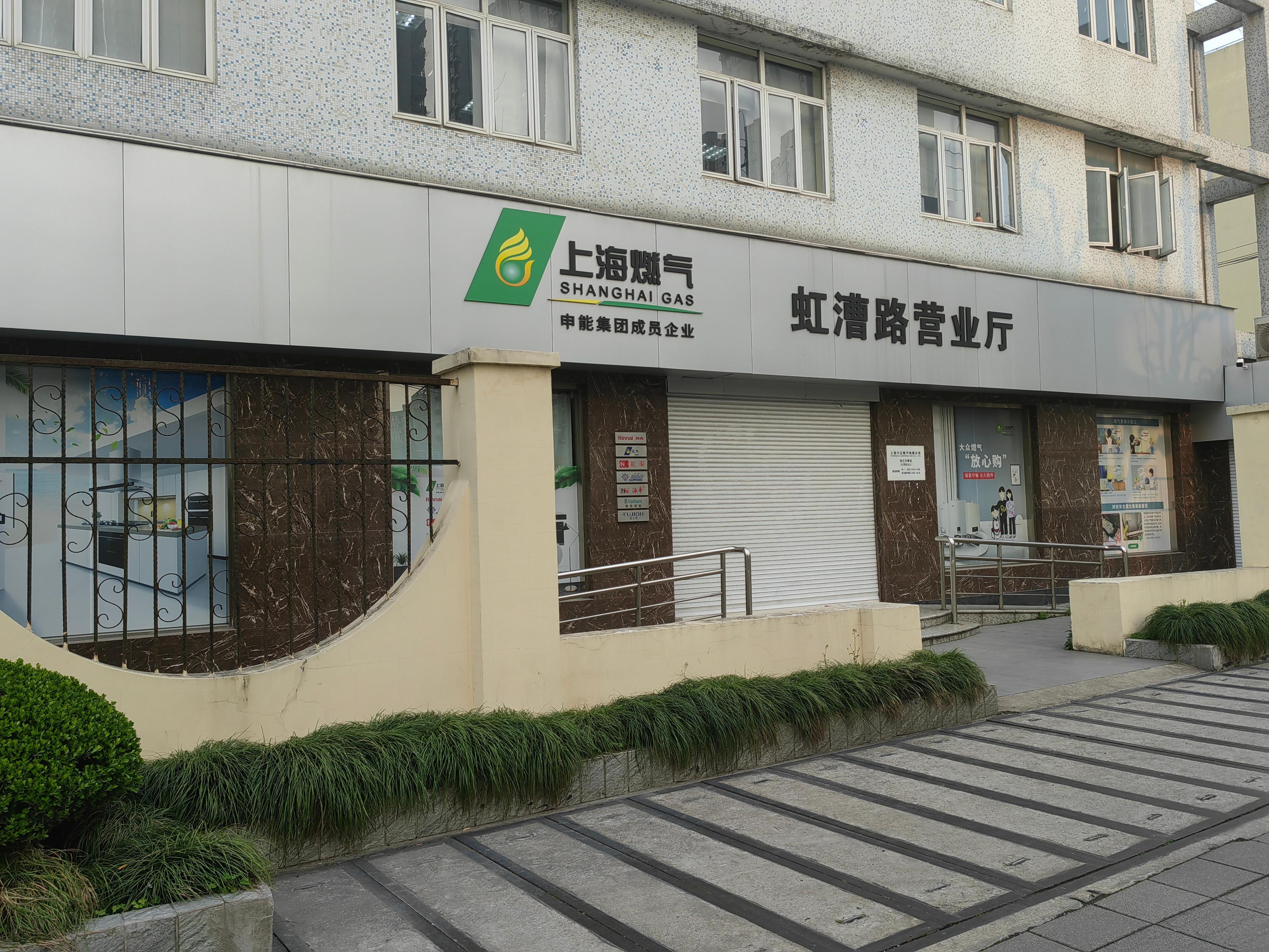 A building with a sign for 'Shanghai Gas' and another sign for 'Huihui Shopping Mall.'