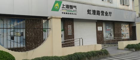 A building with a sign for 'Shanghai Gas' and another sign for 'Huihui Shopping Mall.'
