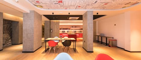 A modern interior with a dining area, kitchen, and a ceiling with architectural drawings.