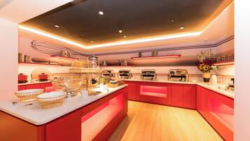 A modern kitchen with red cabinetry, a central island, and various appliances.