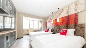 Une chambre d’hôtel avec deux lits, une grande fenêtre, un mur en marbre et une vue sur la ville.