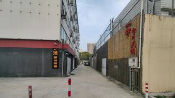 A narrow urban street with a building featuring a red awning and a sign with Chinese characters.