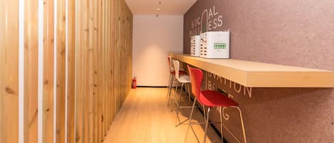 A modern interior with a wooden partition, a reception desk, and red chairs.