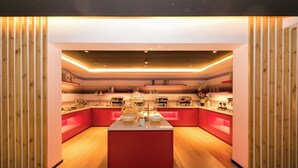 Une cuisine moderne dotée d’un îlot central, de lambris en bois et d’appareils électroménagers intégrés.